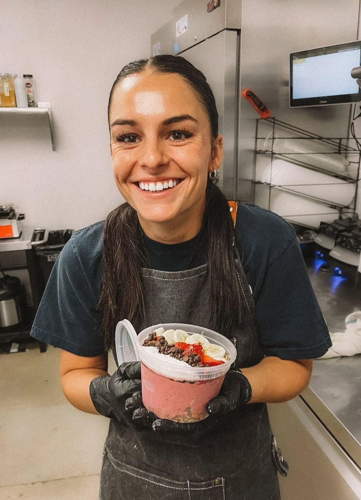 Ola team member holding a fresh açaí bowl