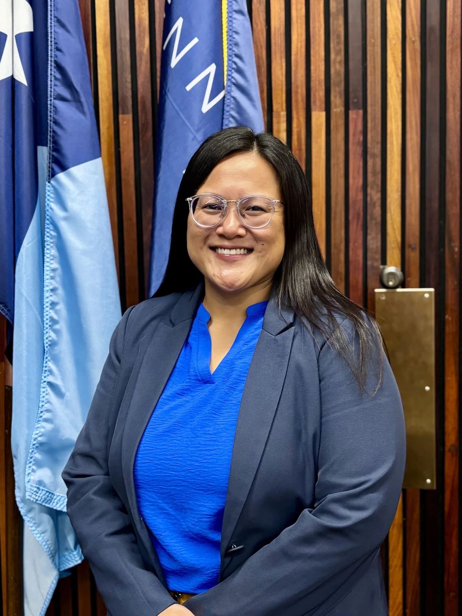 Irene Fernando, Hennepin County Commissioner for District 2, standing before the Minnesota and United States flags