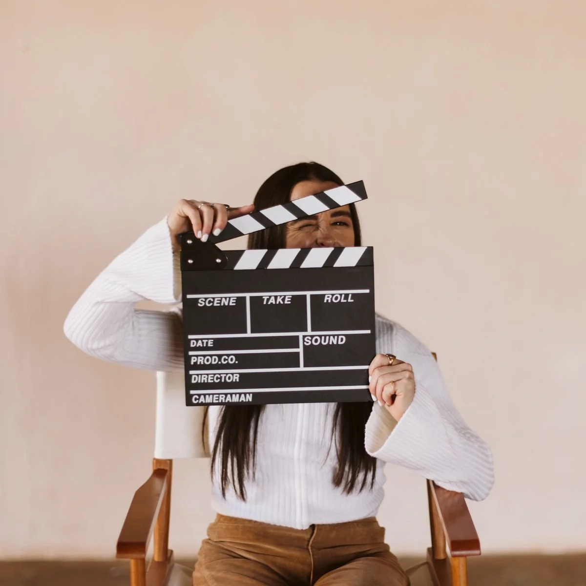 Kaylee peeking out from behind a film clapper