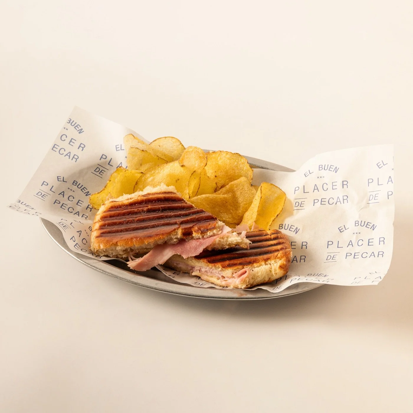 Sándwich de jamón y queso tostado, acompañado de patatas fritas