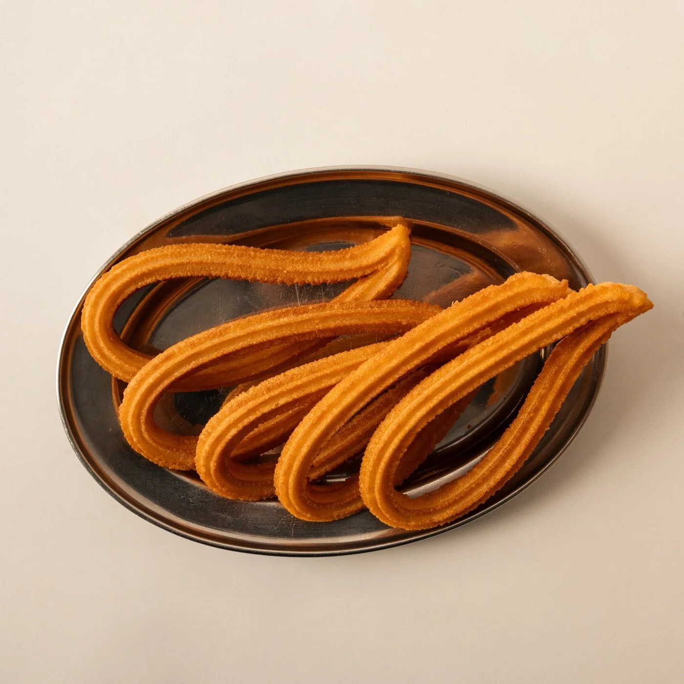 Churros de Manosanta en una bandeja metálica