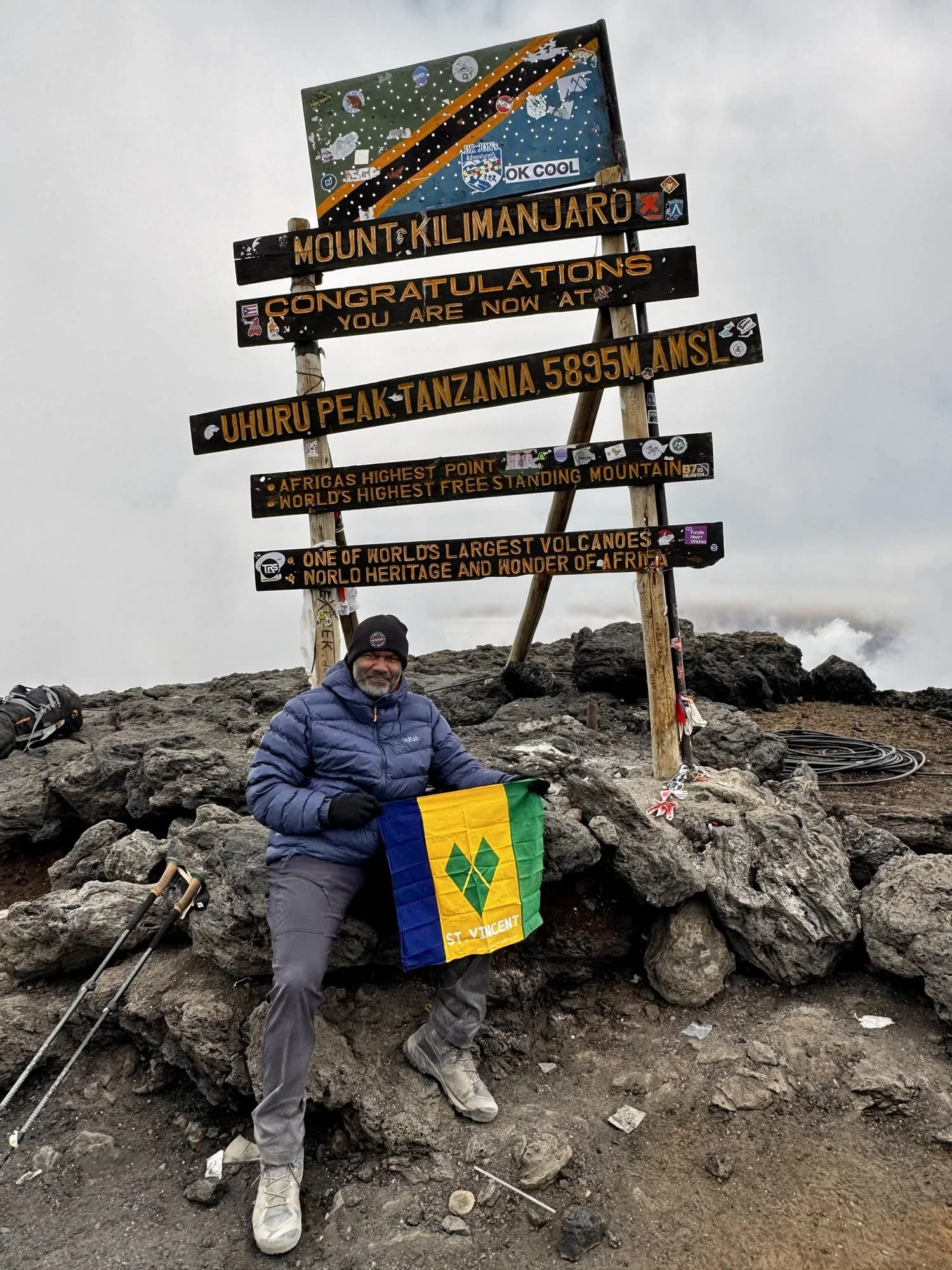 Luciano at Uhuru Peak holding the St Vincent and the Grenadines flag