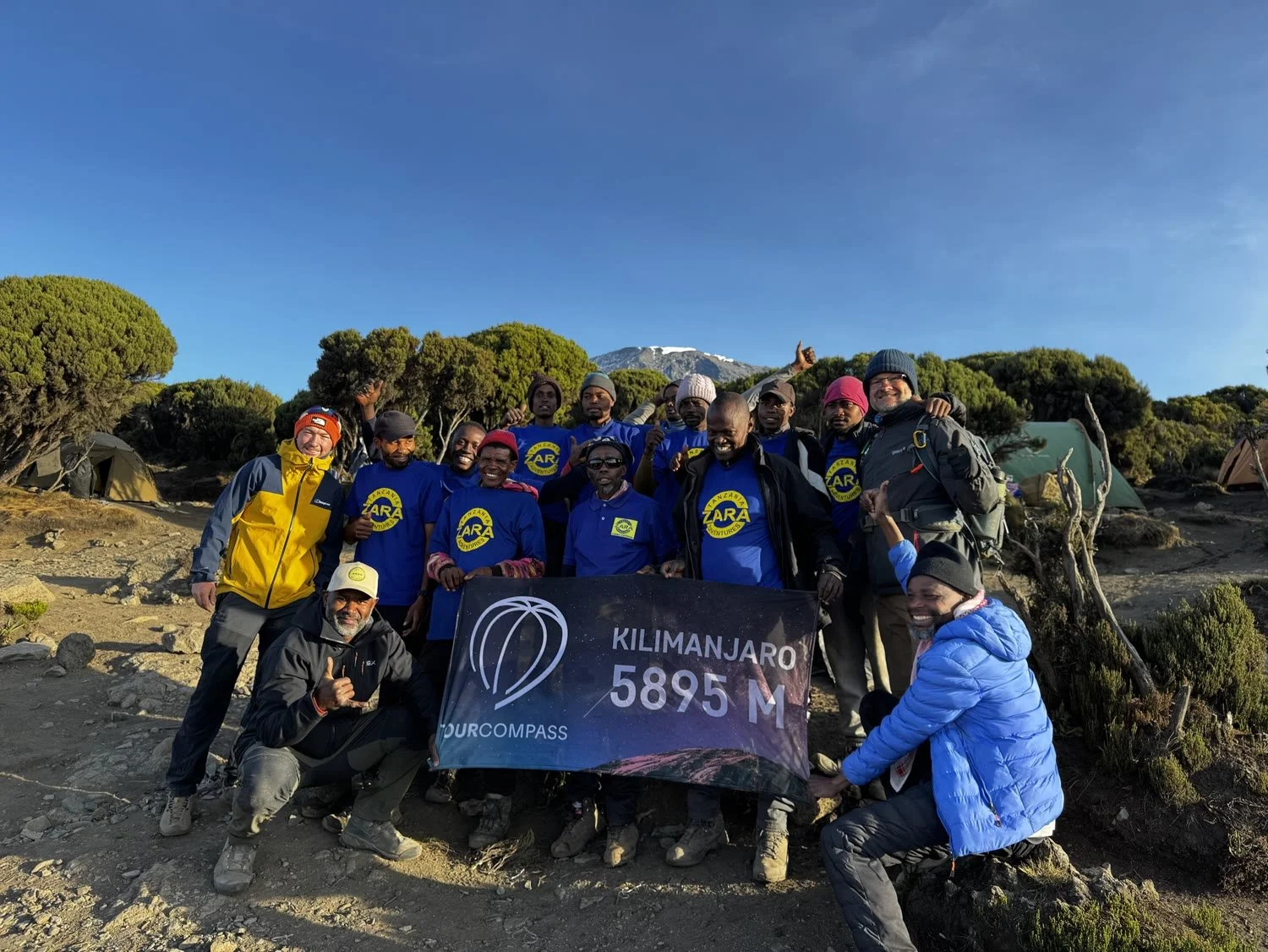 The team with guides and porters holding the 5,895m banner