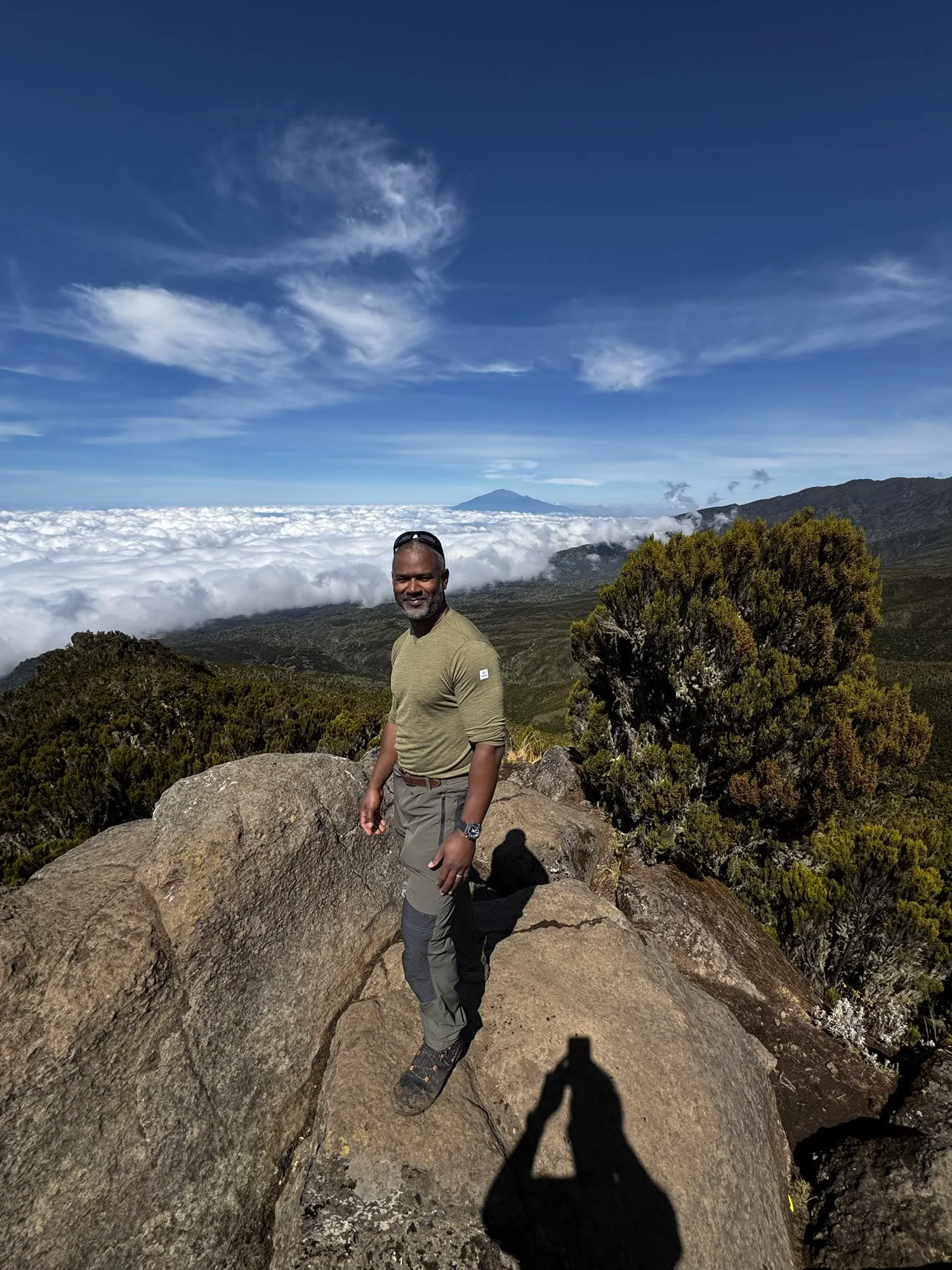 Luciano standing above a sea of cloud on Kilimanjaro