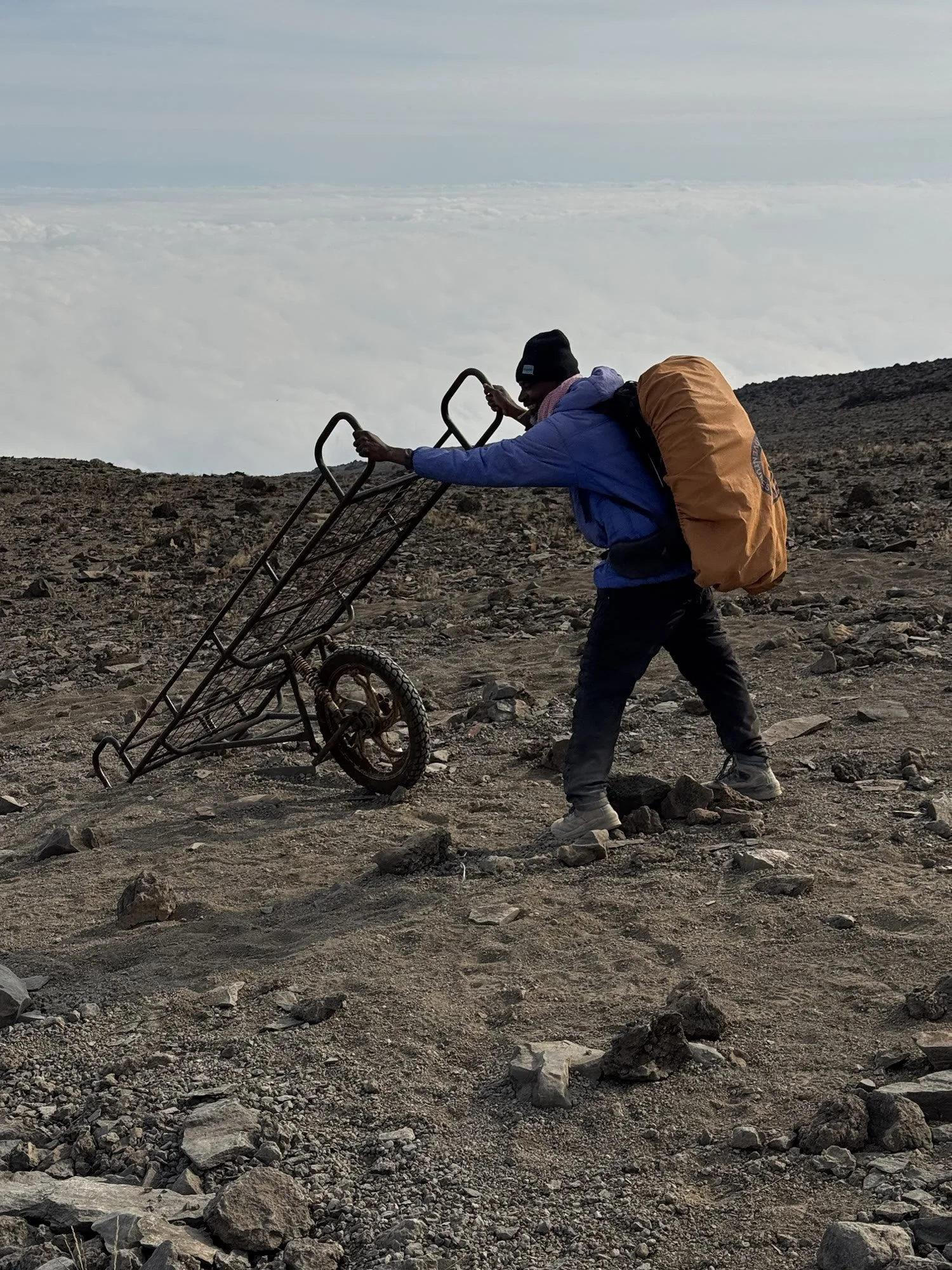 A porter pushing a one-wheeled rescue stretcher