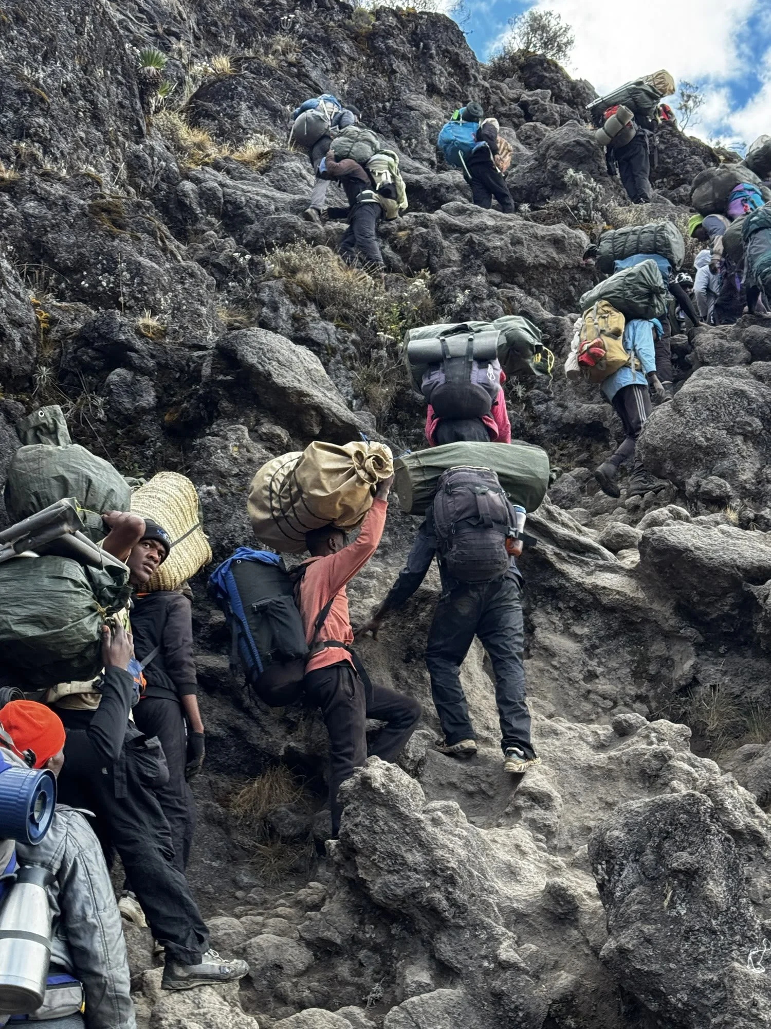Porters climbing the Barranco Wall with loads on their heads and backs