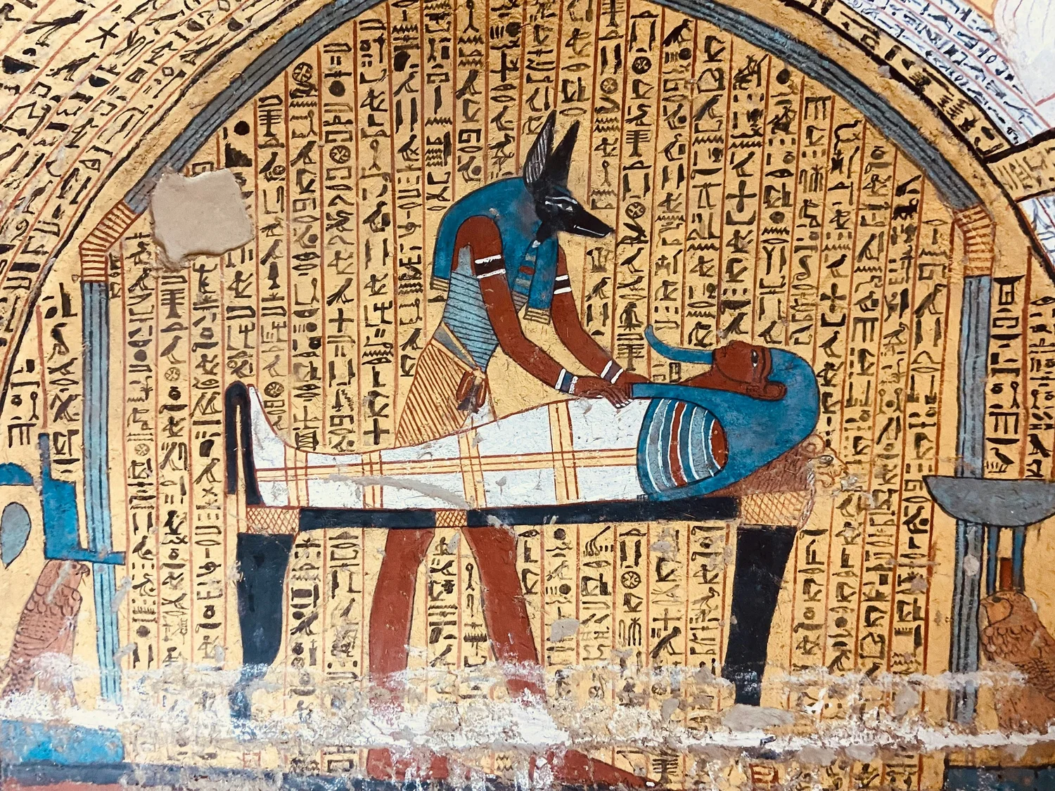 Painted Anubis and hieroglyphs inside an ancient Egyptian tomb