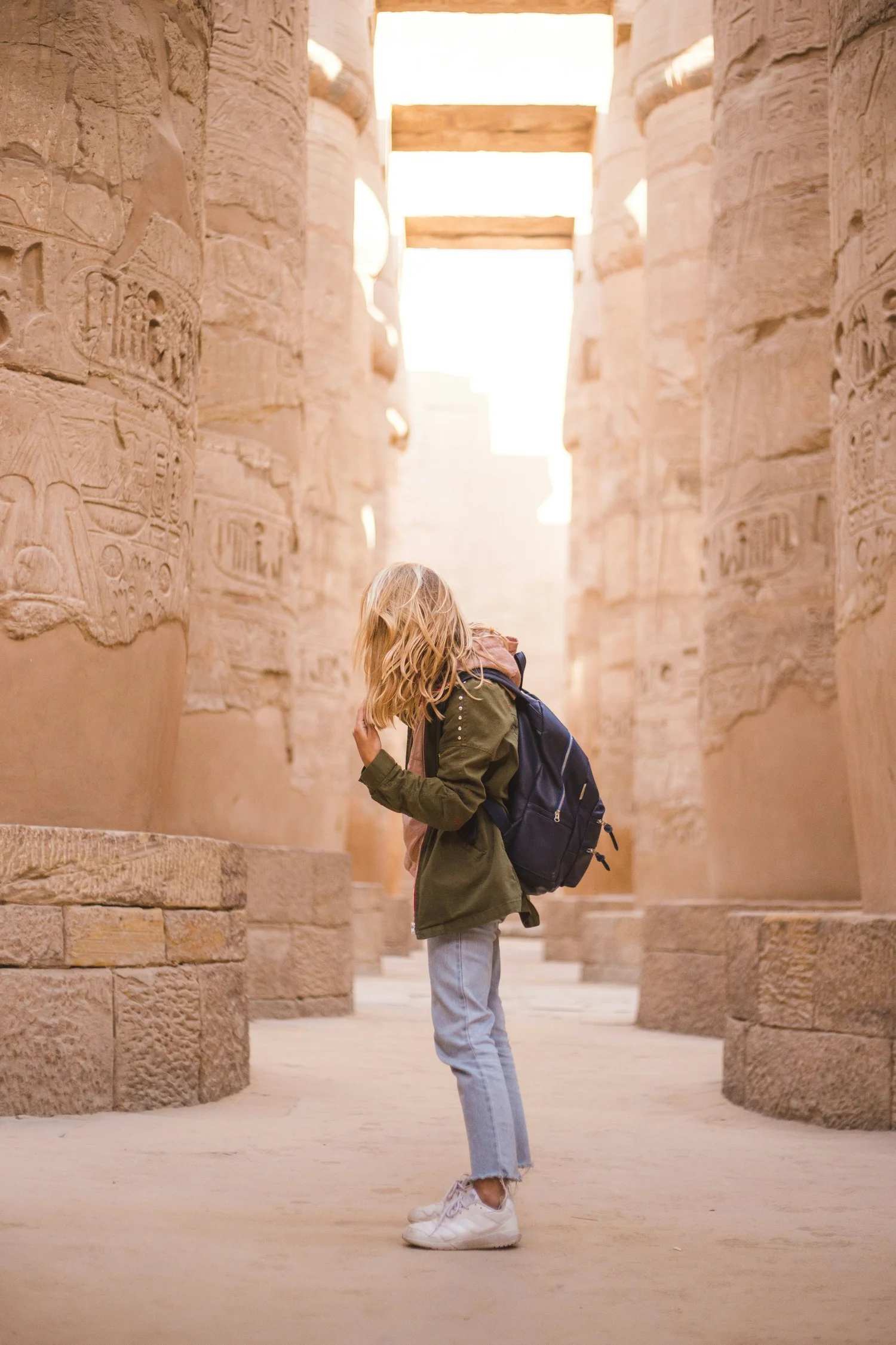 Traveler among the giant columns of Karnak Temple in Luxor, Egypt, on the eclipse yoga retreat