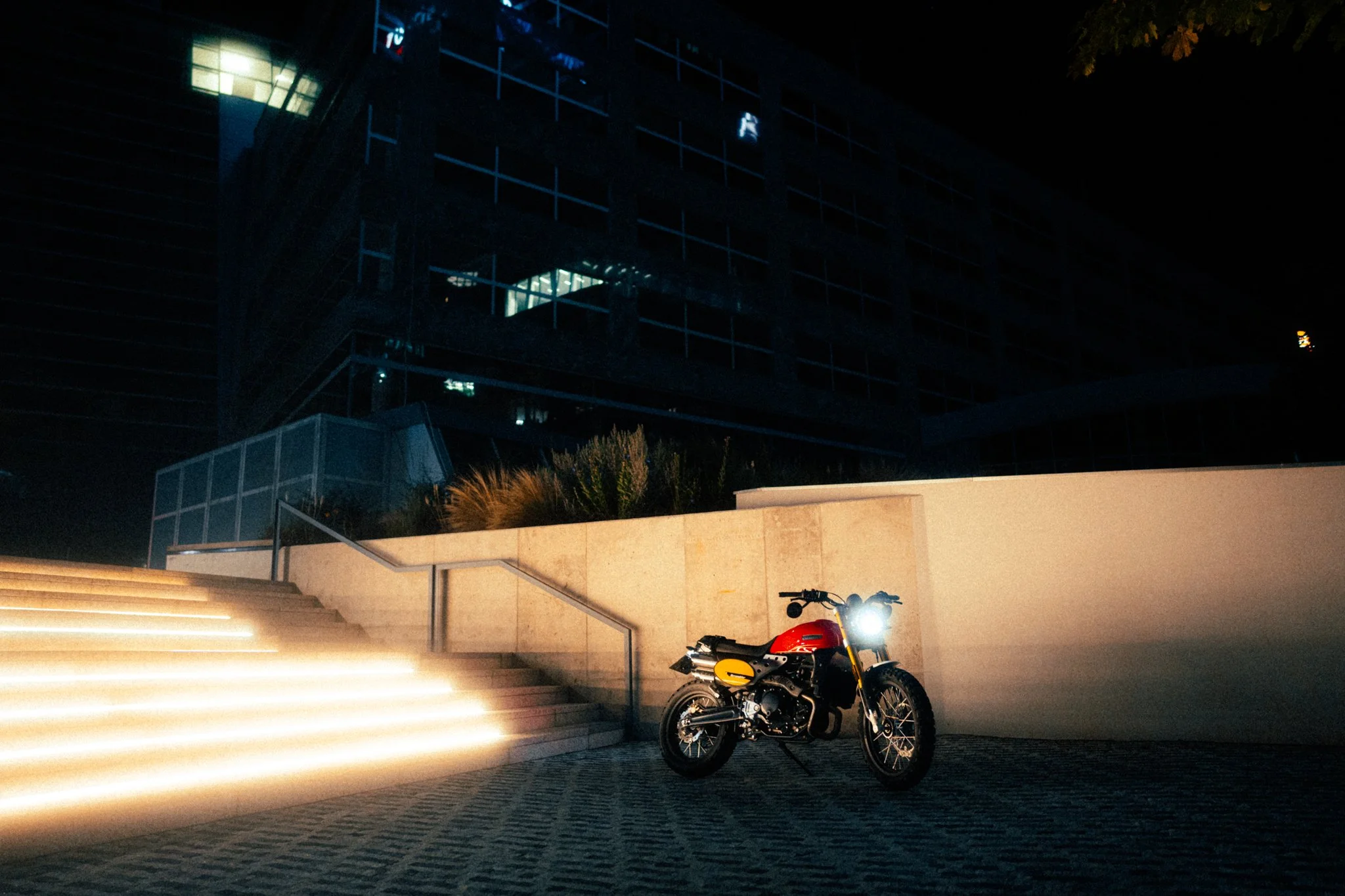 Caballero Scrambler 500 parked by illuminated stairs at night
