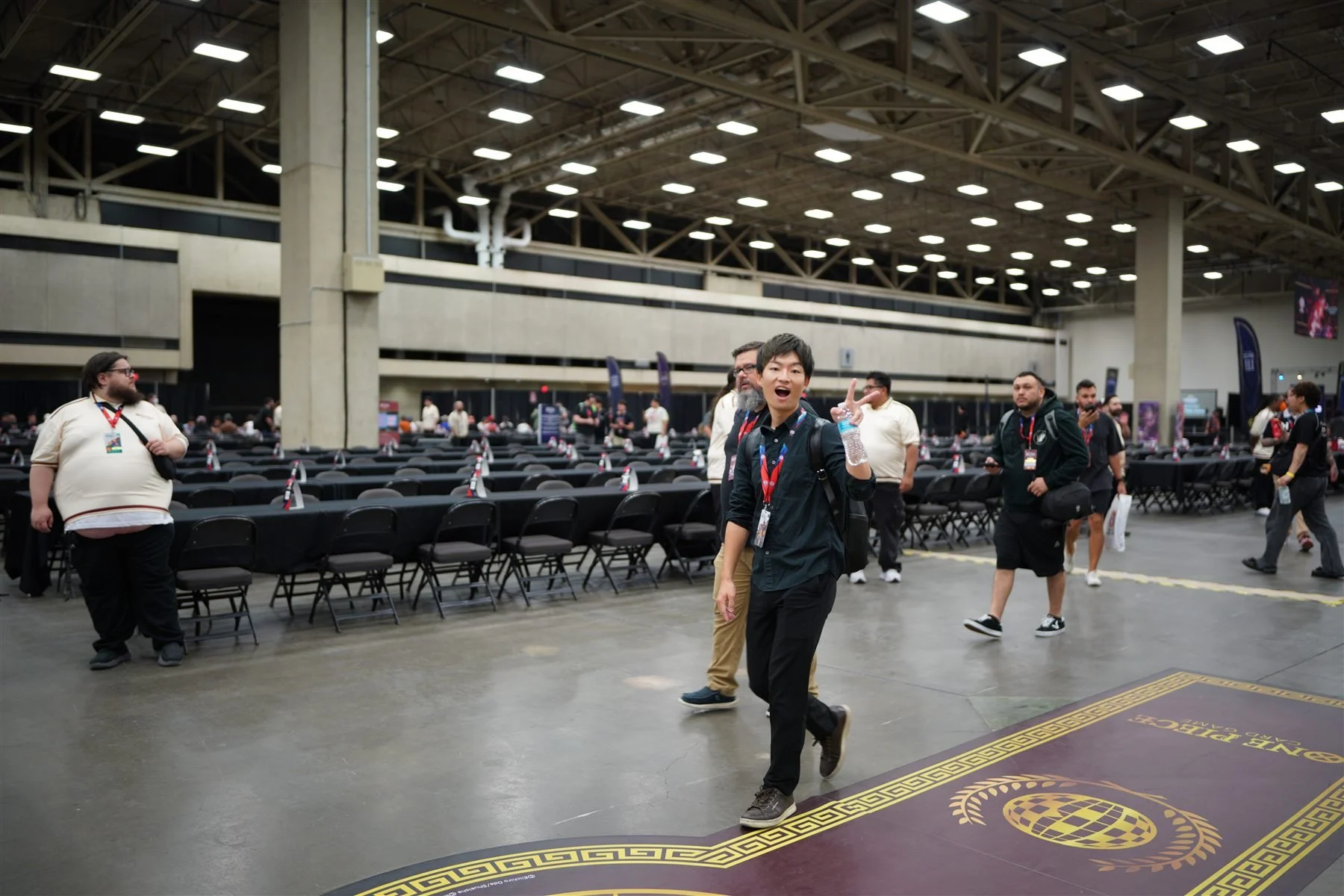 A smiling participant arriving on a branded Dallas event floor graphic