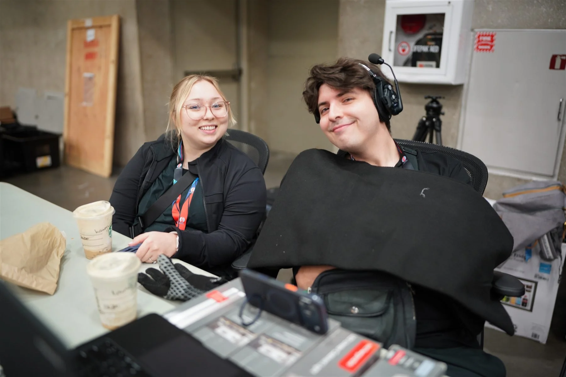 Two production team members at a desk with broadcast equipment at the Dallas event