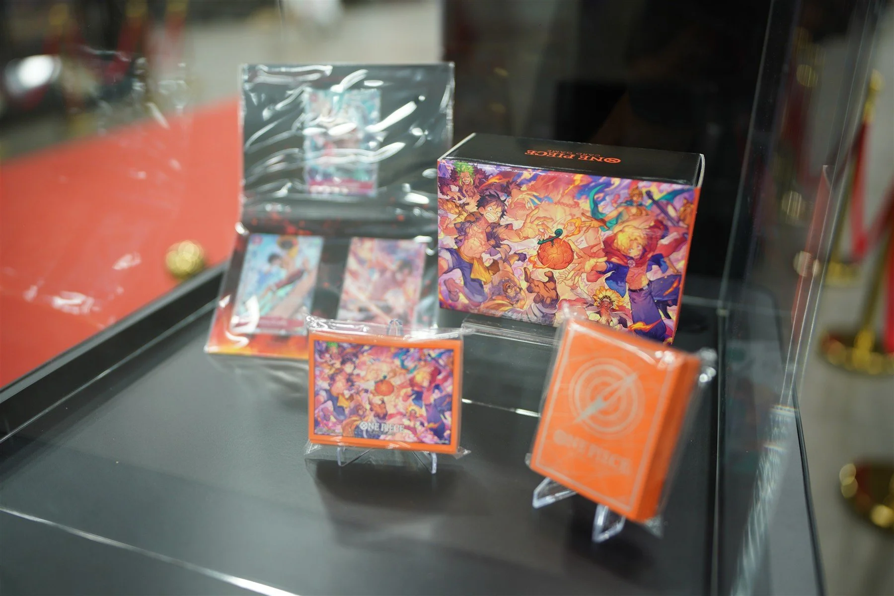ONE PIECE CARD GAME commemorative products displayed in a glass case at the Dallas event