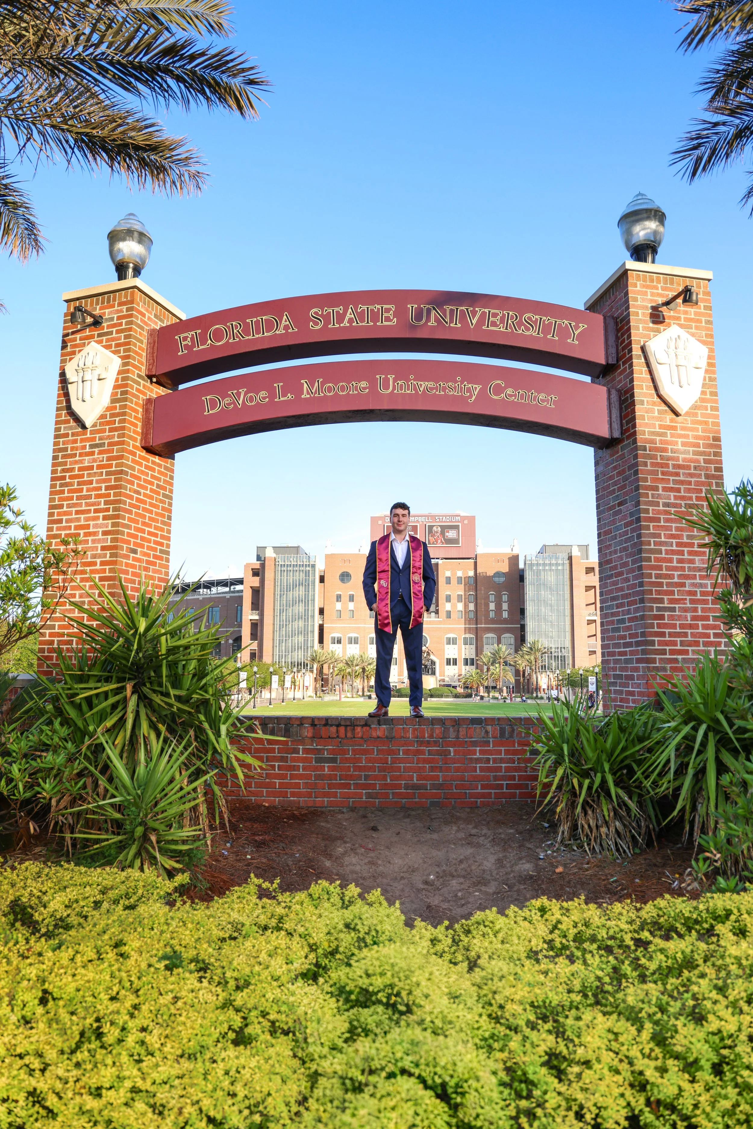 FSU graduate at the Florida State Arch with the stadium in the background