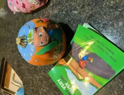 A school pumpkin project decorated to look like the My Very Busy Day book cover