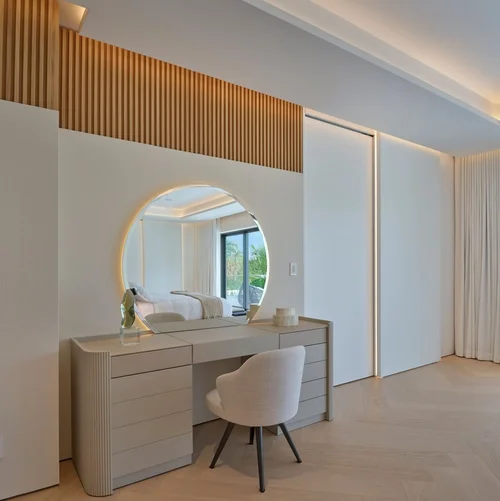 Coiffeuse avec miroir rond rétroéclairé, caissons de tiroirs cannelés et chaise rembourrée, second point de vue