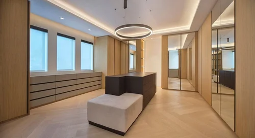 Dressing avec longue commode sous les fenêtres, îlot sombre et banquette, armoires en bois et portes miroir