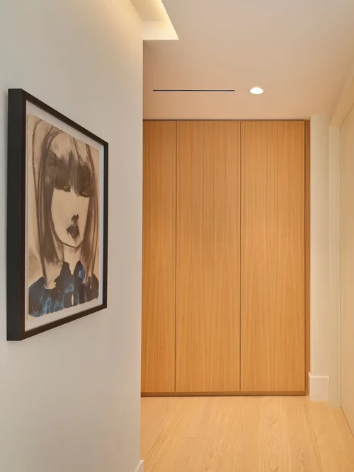 Dégagement avec portrait encadré et armoire en bois toute hauteur au fond