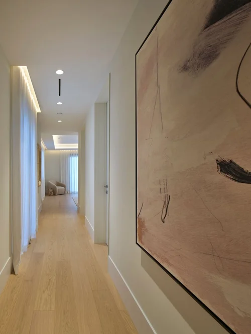 Couloir au sol en bois avec grande œuvre abstraite au mur