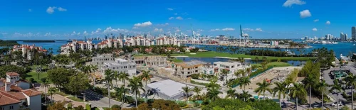 Panorama aérien de Fisher Island avec villas, palmiers, le golf et la baie en direction de Miami