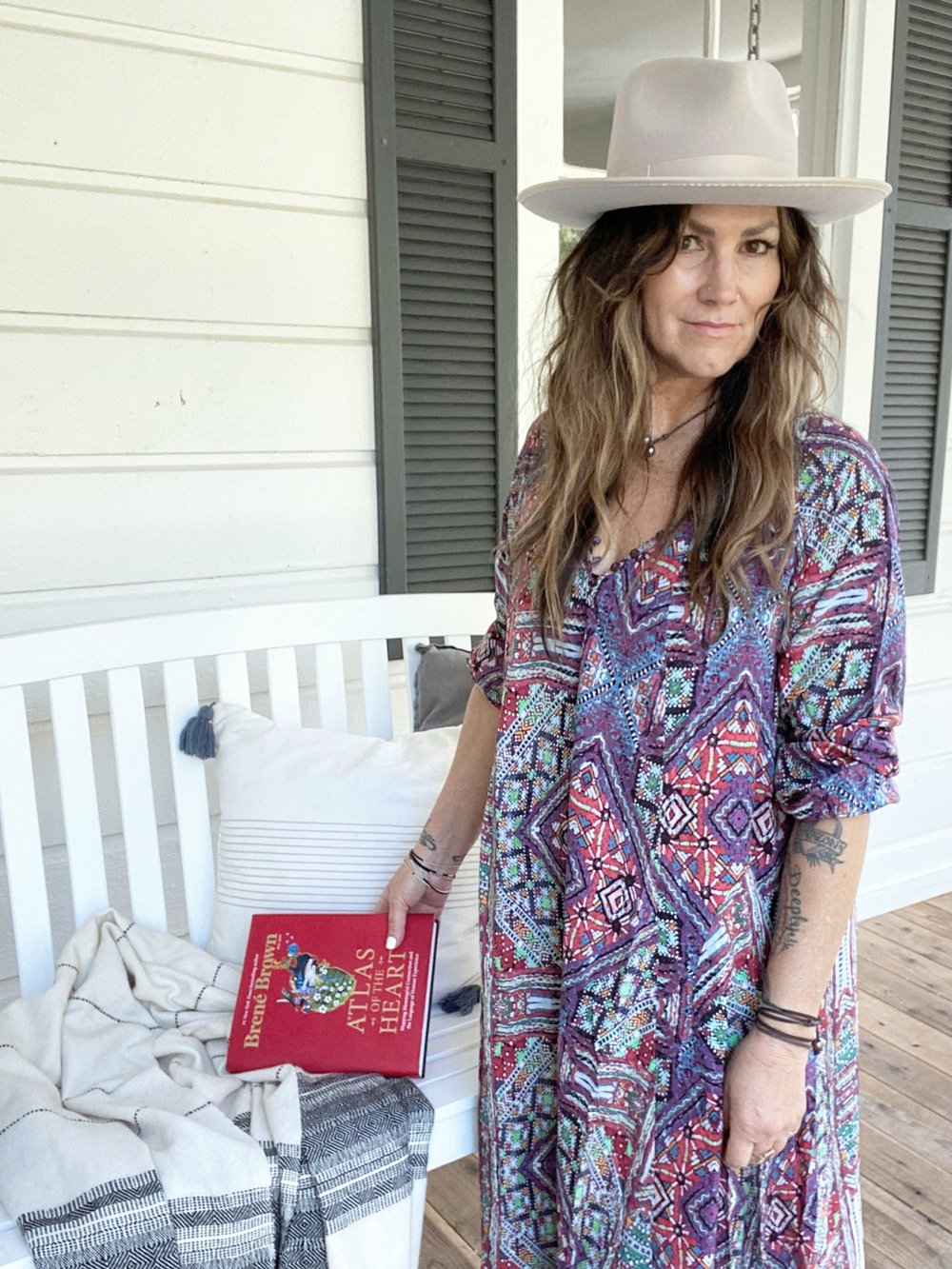 Alise standing on a sunlit porch