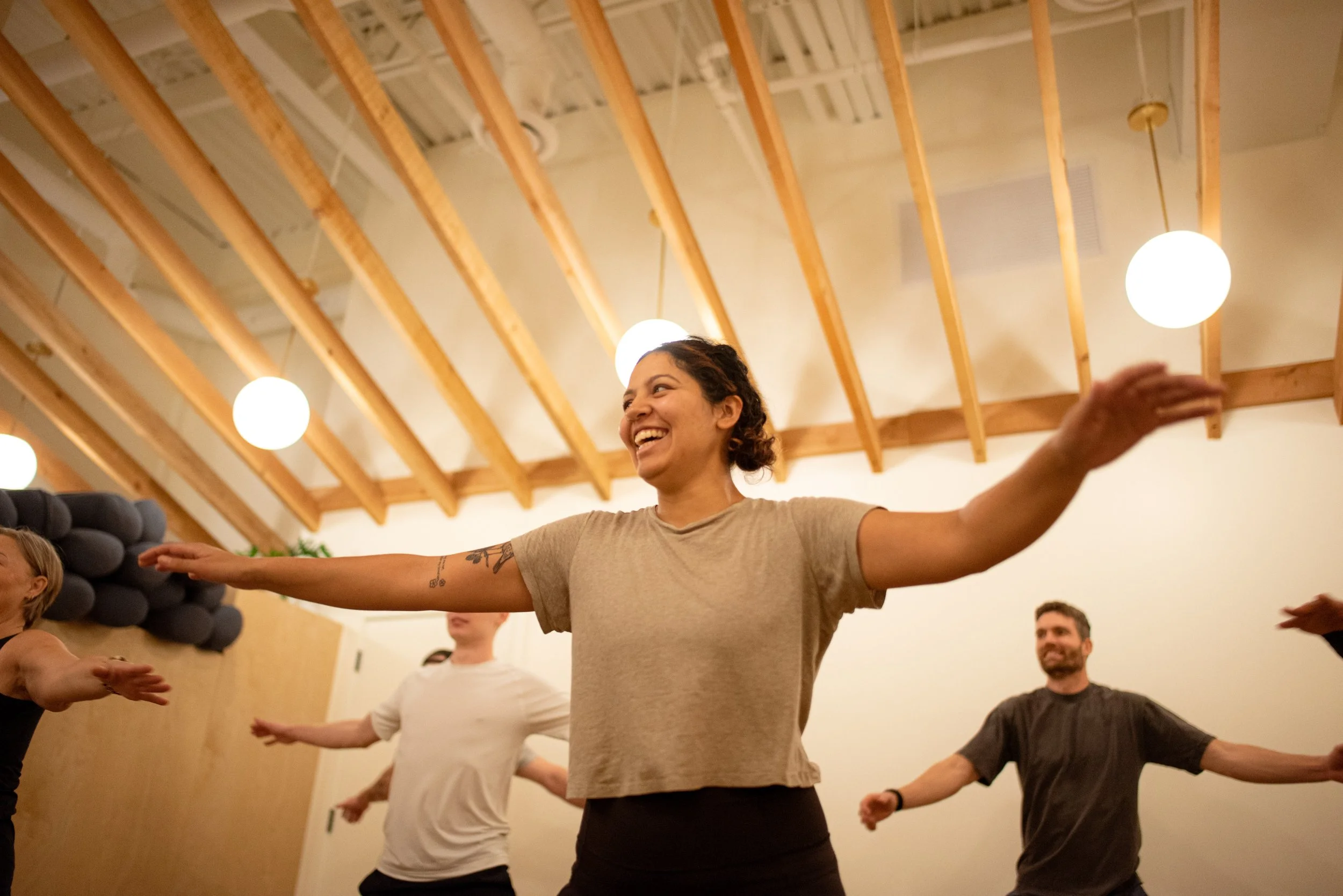 Smiling participants moving together at LAND studio