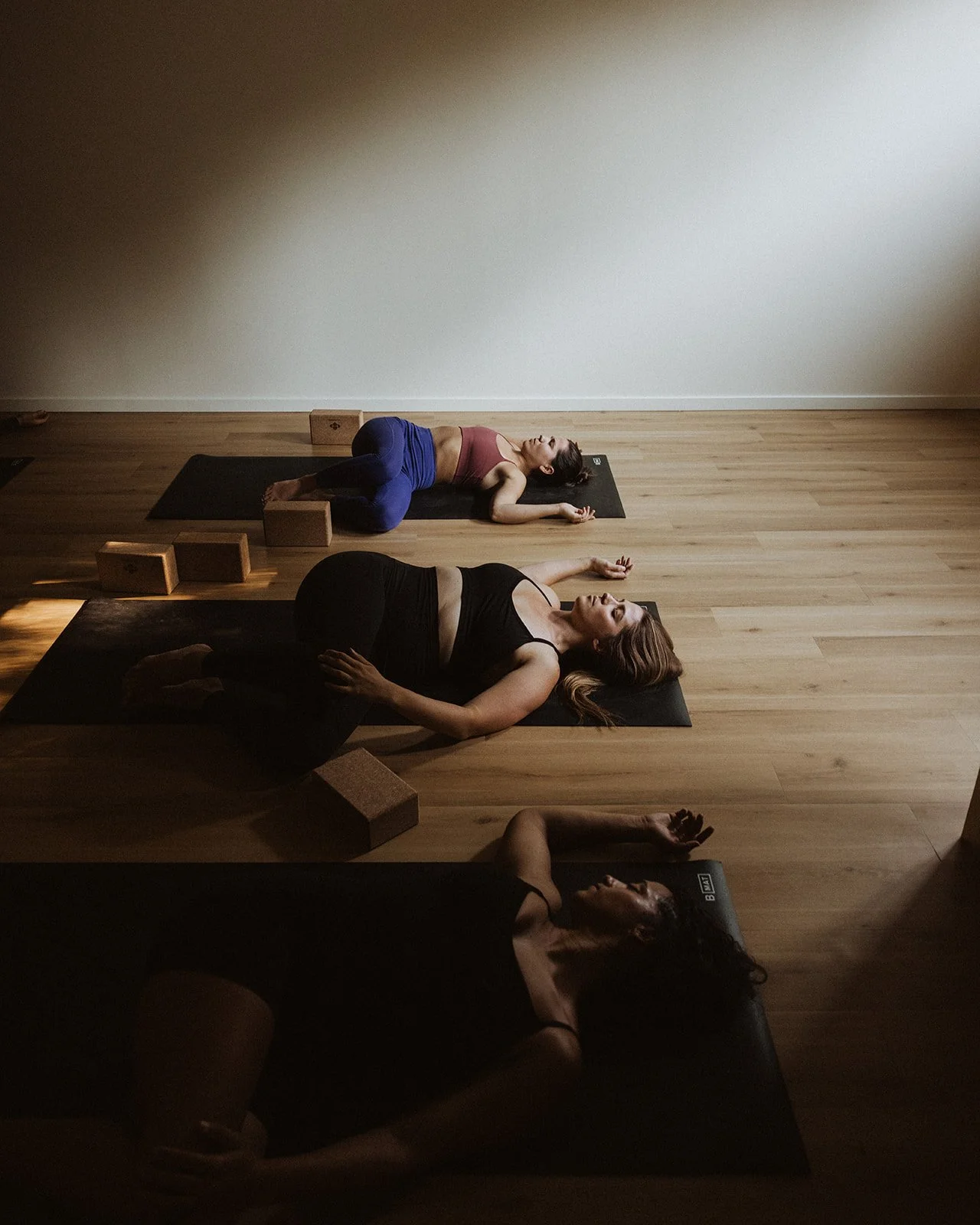 Students resting in supported reclining twists at LAND