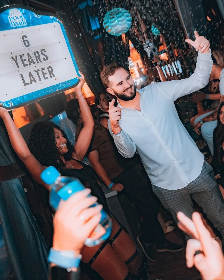 Guests celebrating with a custom bottle service sign in an Atlantic City VIP section