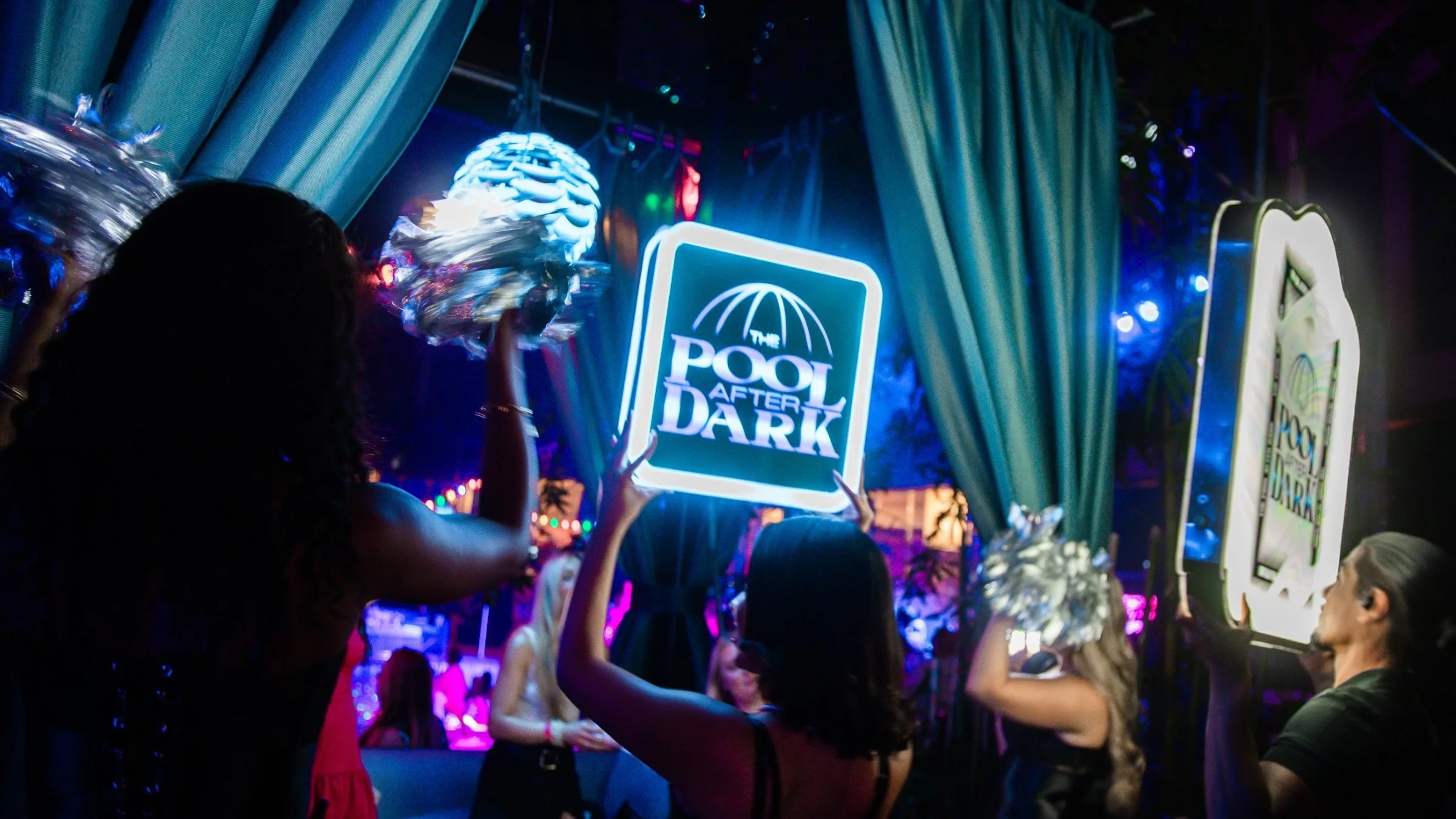 VIP bottle service presentation with a light-up Pool After Dark sign and sparklers in a cabana in Atlantic City