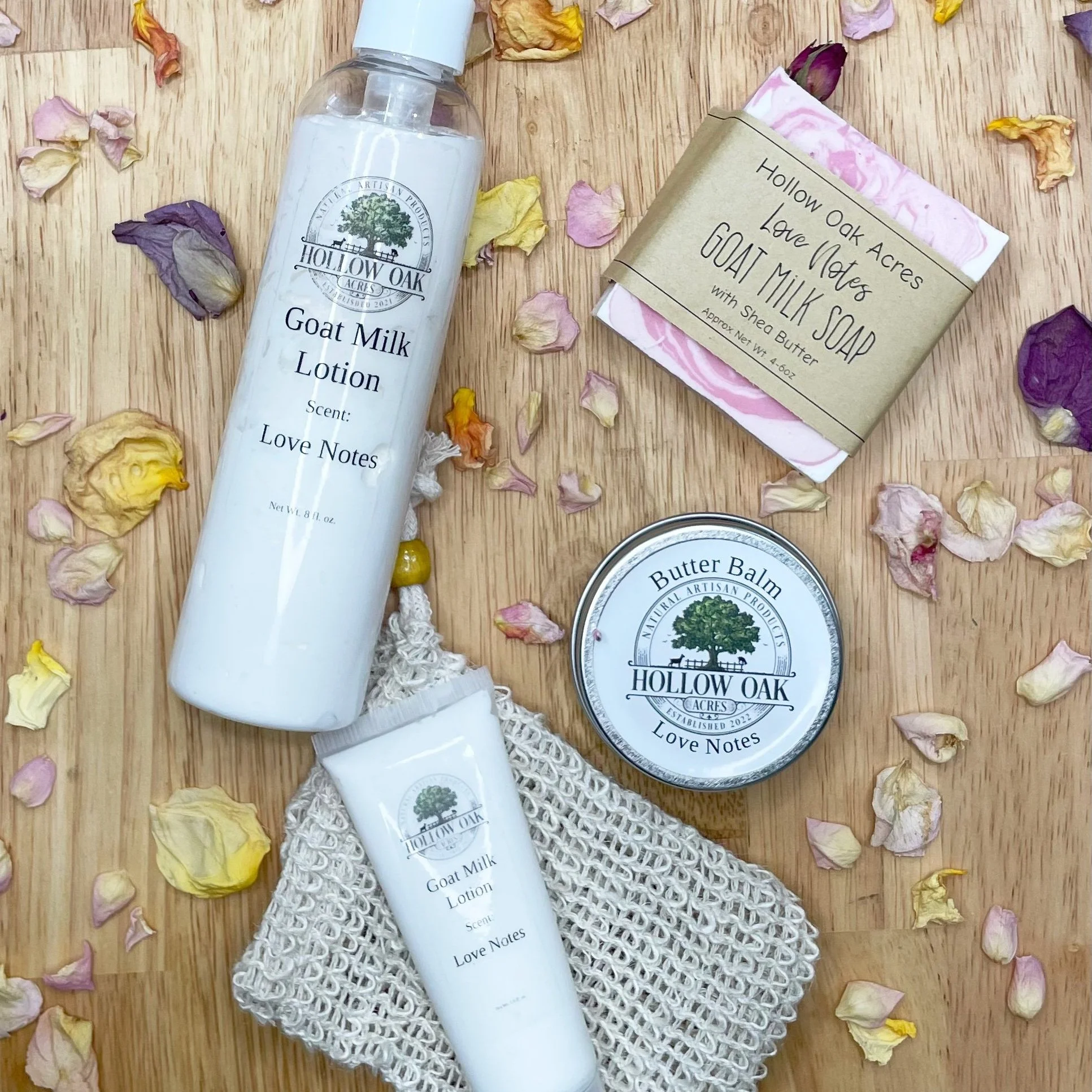 Flat lay of goat milk lotion, butter balm, soap, and soap saver