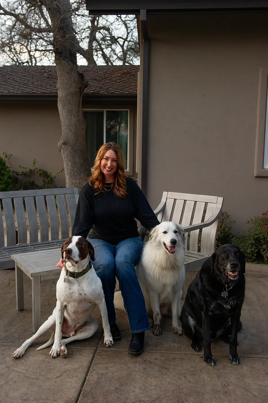 Shelley Vandeveer sitting with three of her dogs on the farm