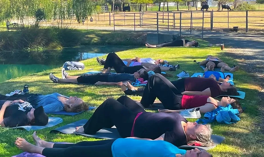 Guests relaxing beside the pond during a Sound Bowl Healing session at Hollow Oak Acres