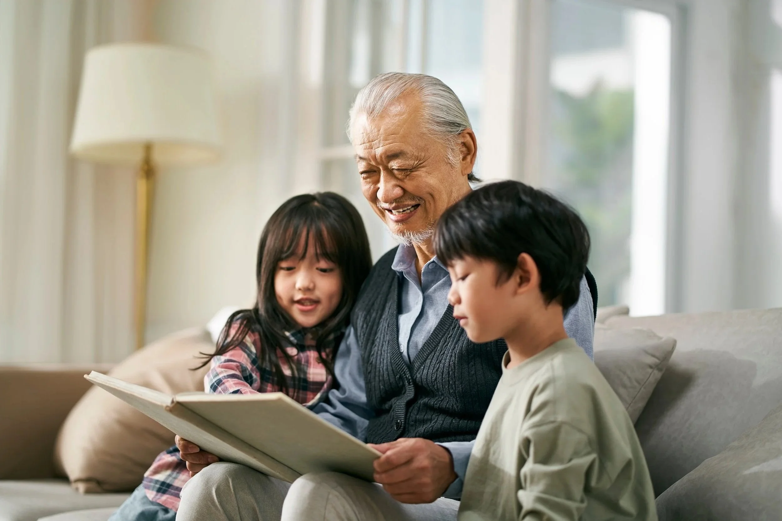 Grandfather reading with grandchildren