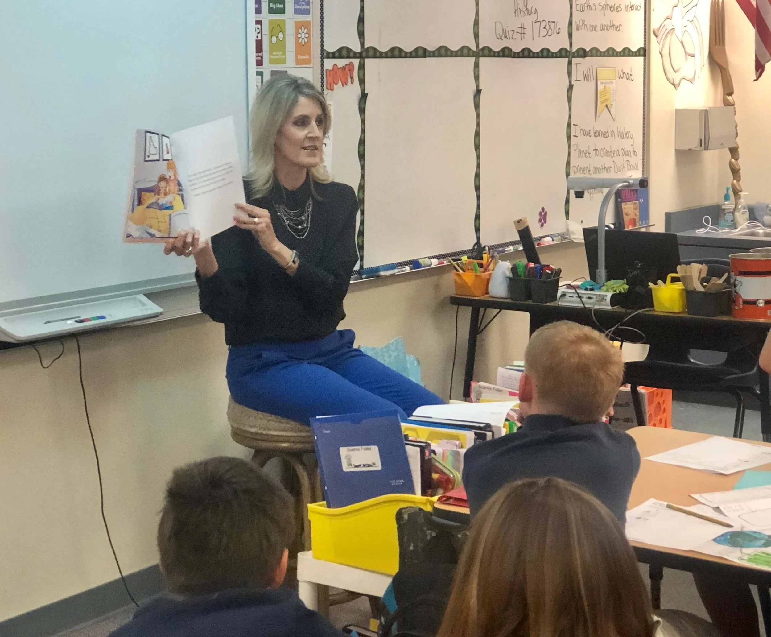 Melissa Hardy reading a picture book to students in a classroom