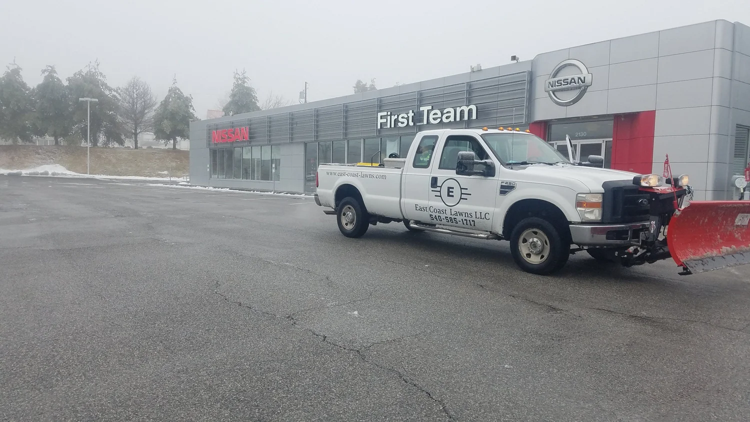 East Coast Lawns plow truck on a cleared commercial lot