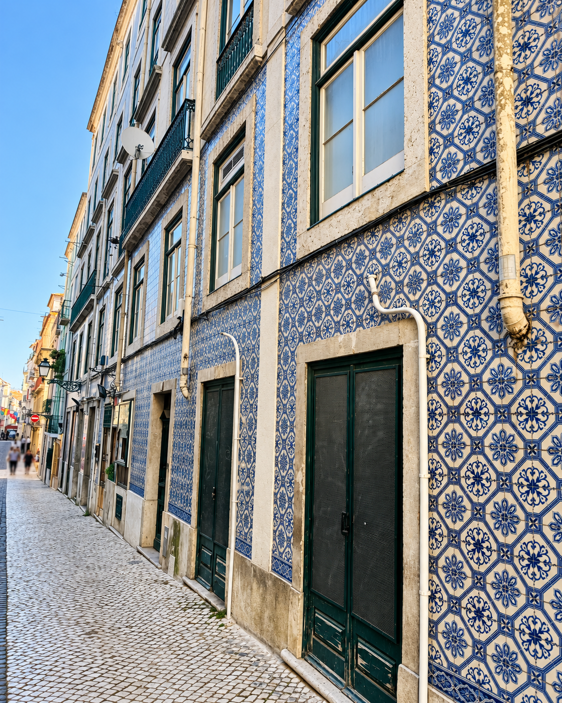 Blue-and-white tiled façade with green doors in Lisbon, photographed by Krystin Krebs