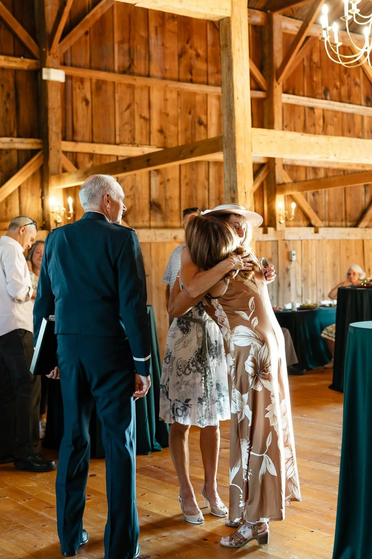 Guests embracing inside the timber-frame barn at William Allen Farm