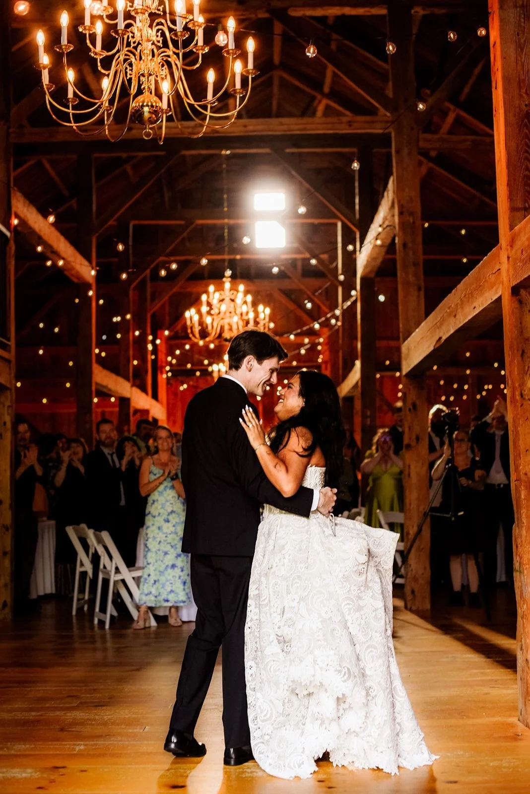 A couple's first dance under chandeliers in the barn at William Allen Farm