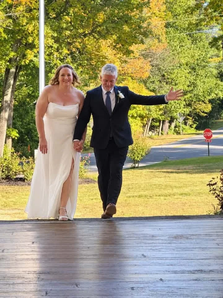 Newlyweds walking hand in hand up onto the barn deck at William Allen Farm on a sunny fall afternoon
