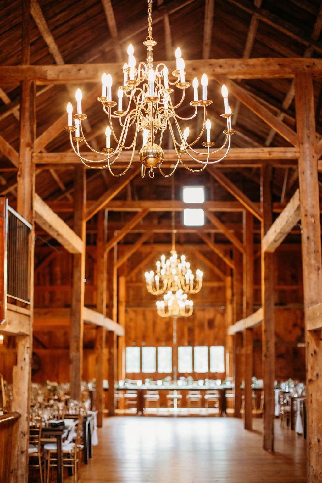 Twin chandeliers hanging down the length of the timber-frame barn