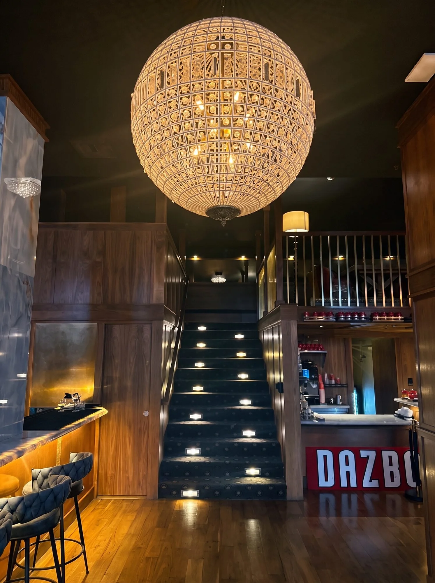 The stairs up to the mezzanine, with a light in every step, under the chandelier