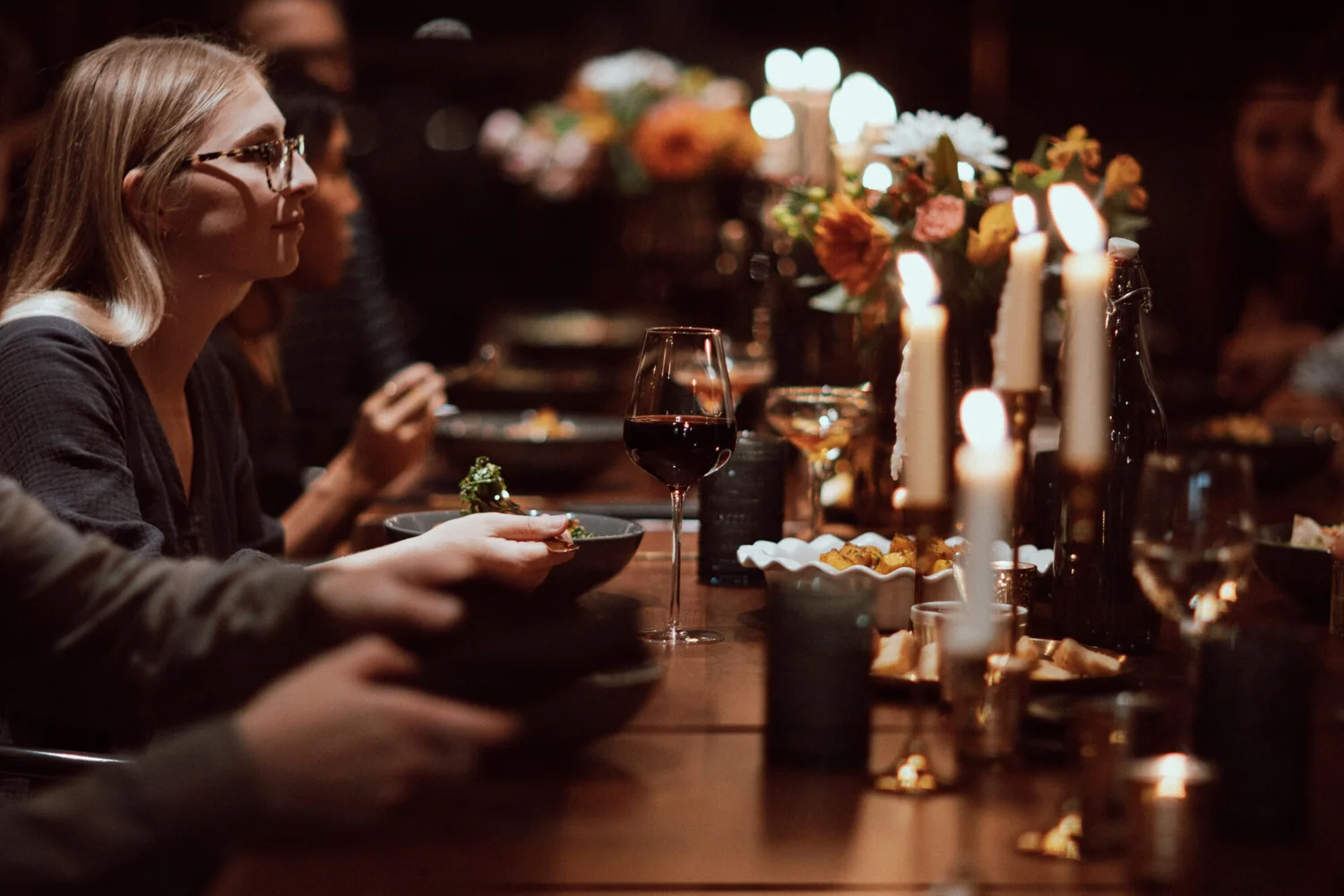 A guest at the long table by candlelight, at a private dinner