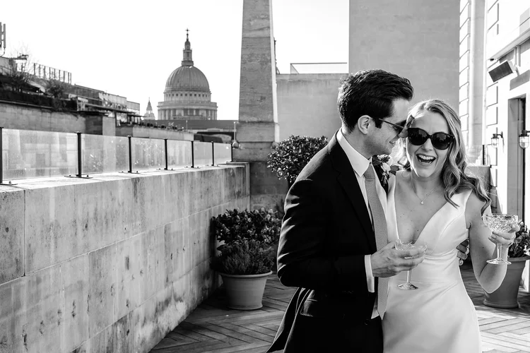 Jess and Tom on the terrace at The Ned with St Paul&rsquo;s Cathedral behind