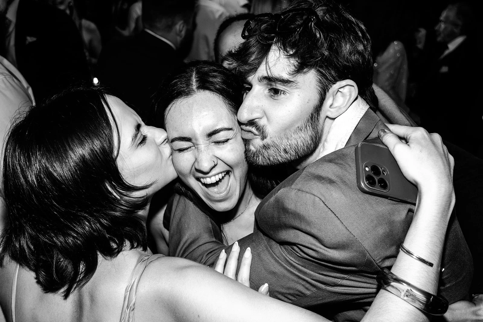 Guests laughing and hugging on the dance floor at the end of Jack and Abi's wedding at Limekiln — real, joyful, black and white