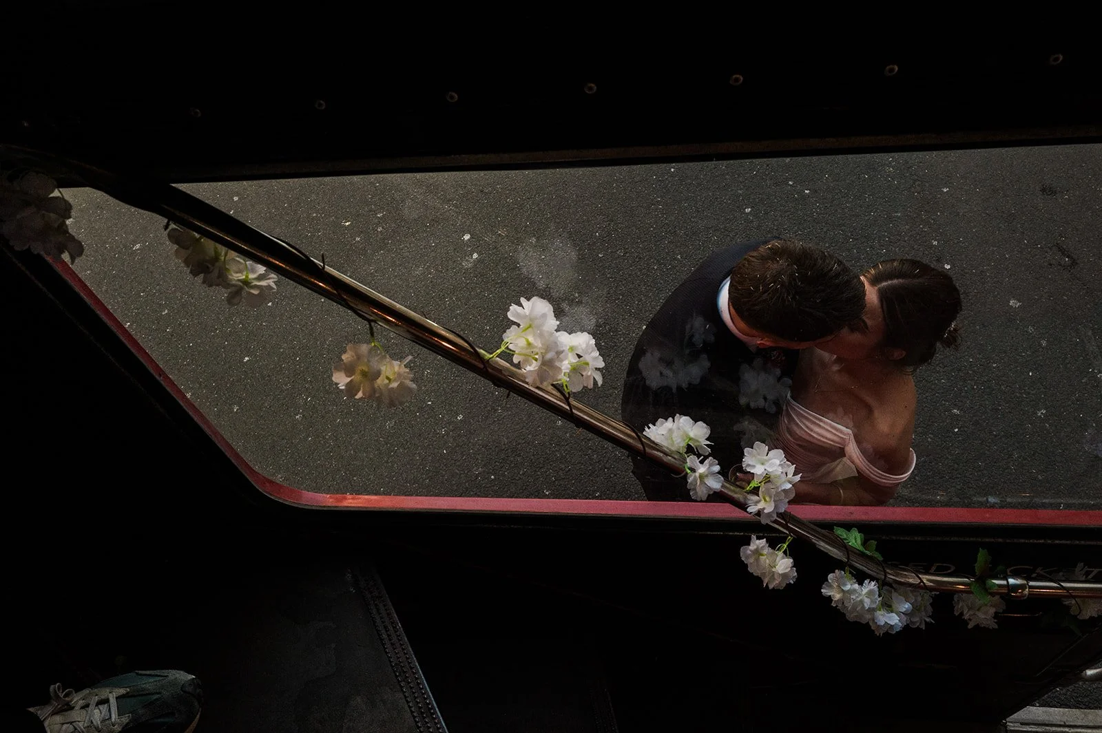 Nat and Josh kissing seen from above the bus with cherry blossom