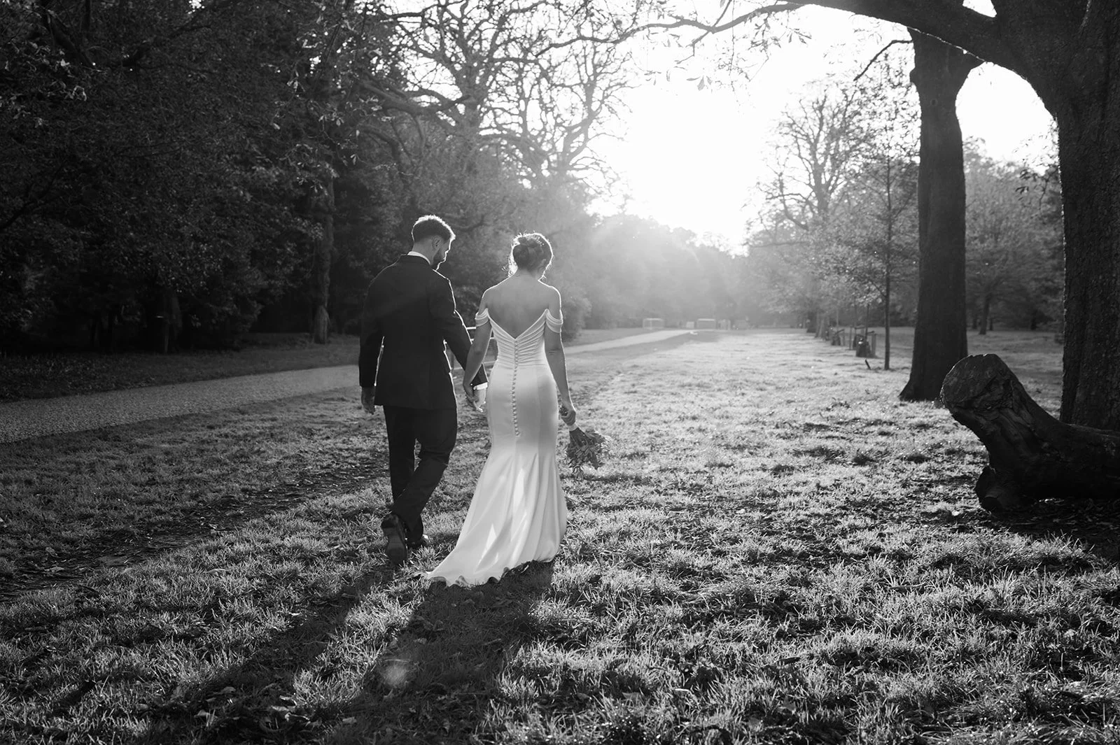 Nat and Josh walking away together through the park, backlit by golden sun