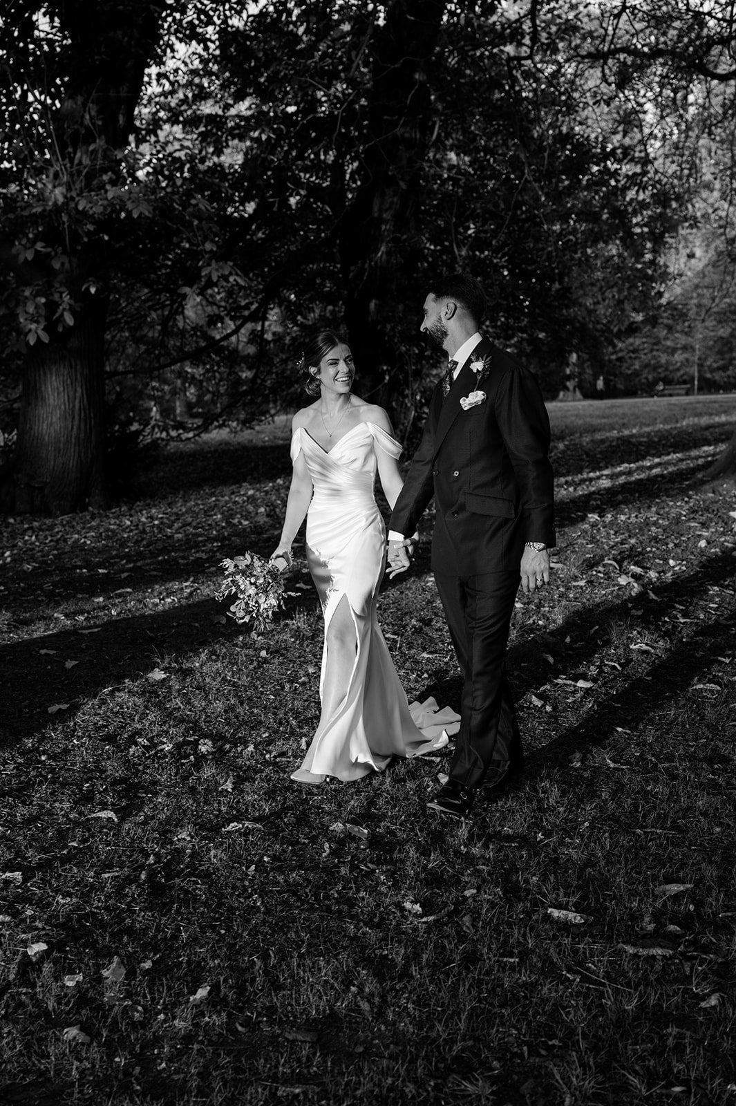Nat and Josh walking through the park in black and white