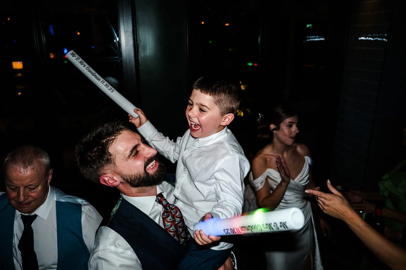 Josh holding his son with foam sticks on the dance floor