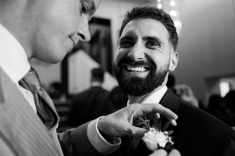 Buttonhole being pinned before a wedding ceremony in Chelsea