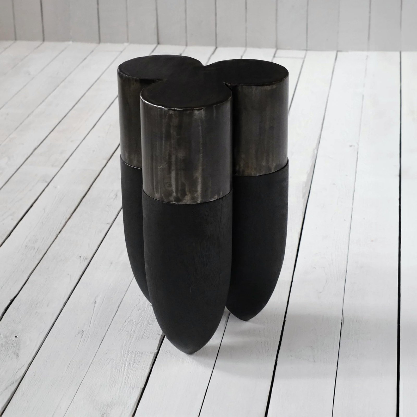 Closer view of the patinated steel and rounded wooden forms of the Senufo Side Table by Arno Declercq.