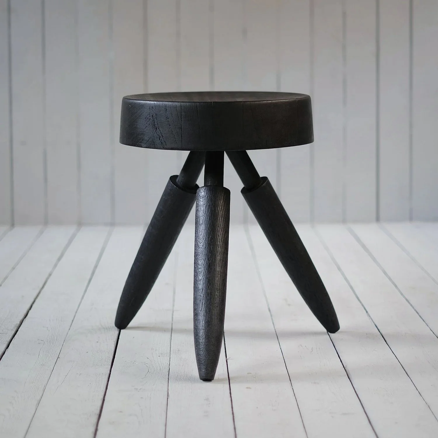 Closer view of the circular wooden seat and angled legs of the Senufo Tabouret by Arno Declercq.
